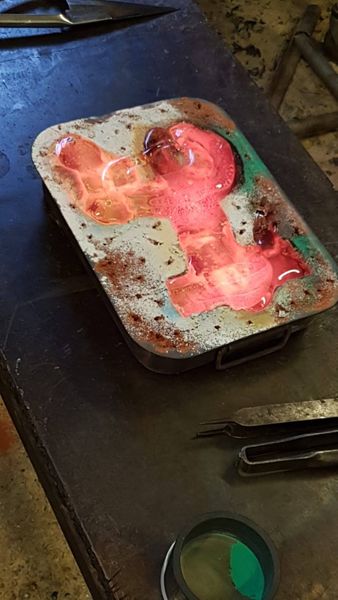 hot glass cast in the sand mould 