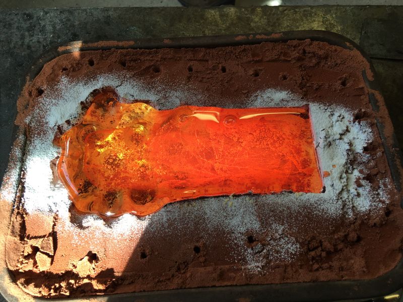 hot glass cast in the sand mould 