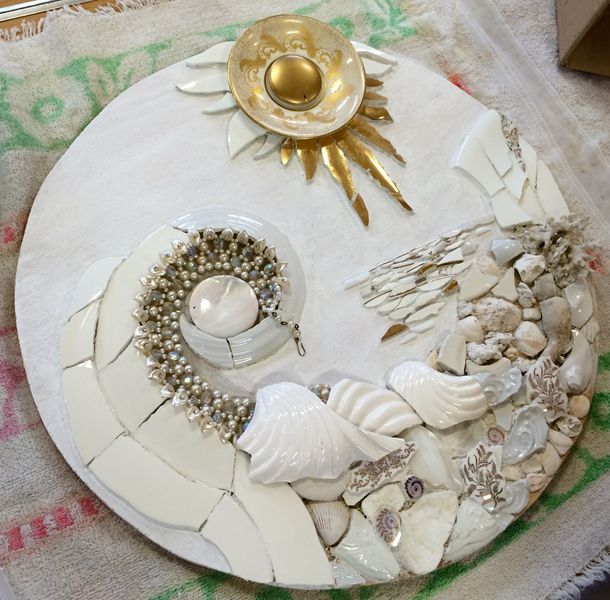 A mixed media mosaic made using vintage china, old jewellery, shells, marble and stones.

