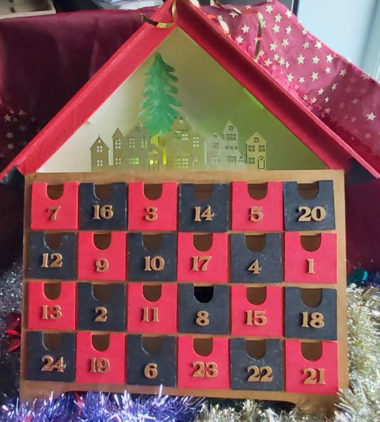 Light Up Calendar with multi coloured lights shining through the buildings