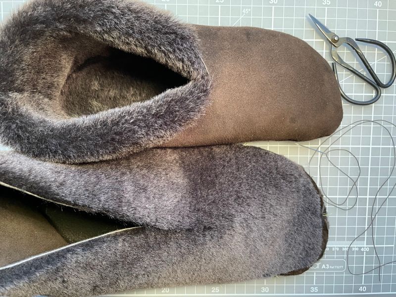 A photo showing the right slipper under construction and the left one finished.