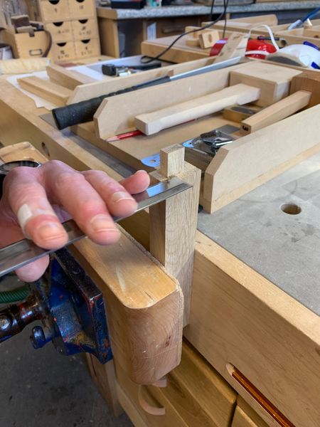 Paring the shoulder of a tenon with a sharp chisel.