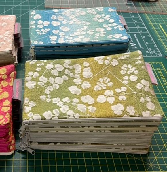 pile of identical pouches in green jaquard