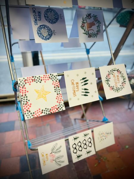 Examples of printed Christmas cards made by participants at a Christmas Paper workshop in December 2024