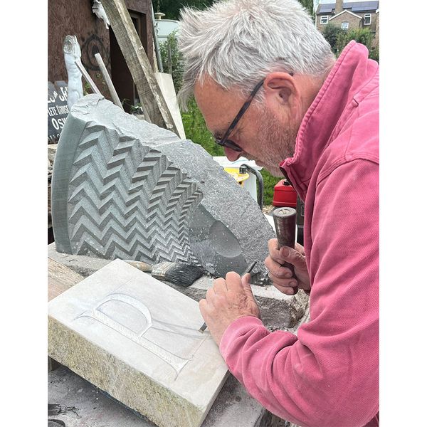 Stone mason carving letters
