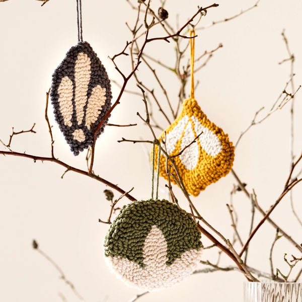 Punch needle baubles hanging from a twig tree