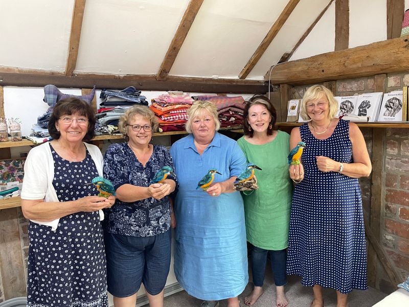 Happy first-time needle felters holding their finished Kingfishers at The Oast Studio 