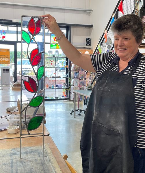 Clare and the stained glass panel she designed and made