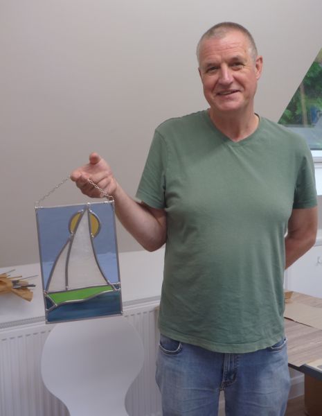 A happy visitor with his finished stained glass panel!