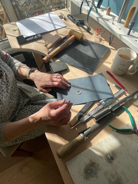 Lady sanding down silver rings on abrasive paper