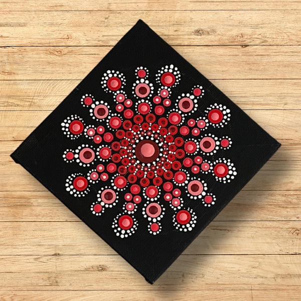 Dot mandala canvas using two layers of paint in reds and pinks