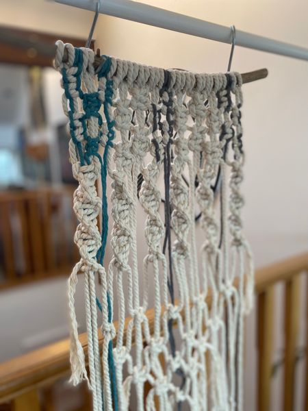 Macramé wall hanging with coloured stripe detail.