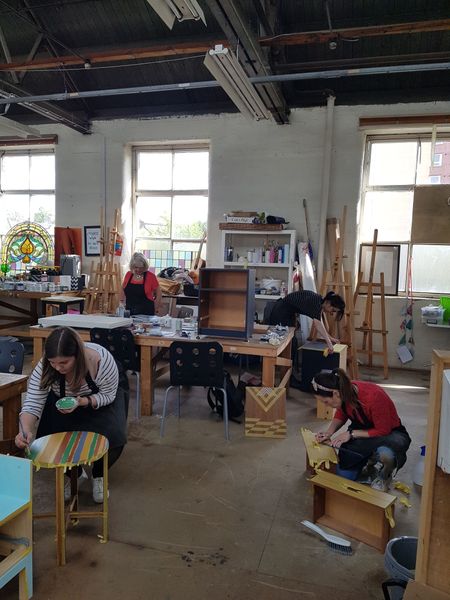 Painting geometric designs on the Furniture Upcycling workshop