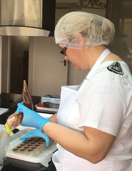 Student filling decorated chocolate moulds