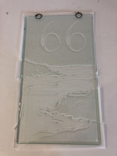 Fantastic Kiln carving piece featuring a dramatic coastline and house number.
