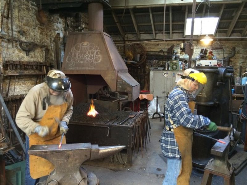Two ladies learning new skills  during the Blacksmith Experience day at the Hot Metal Works
