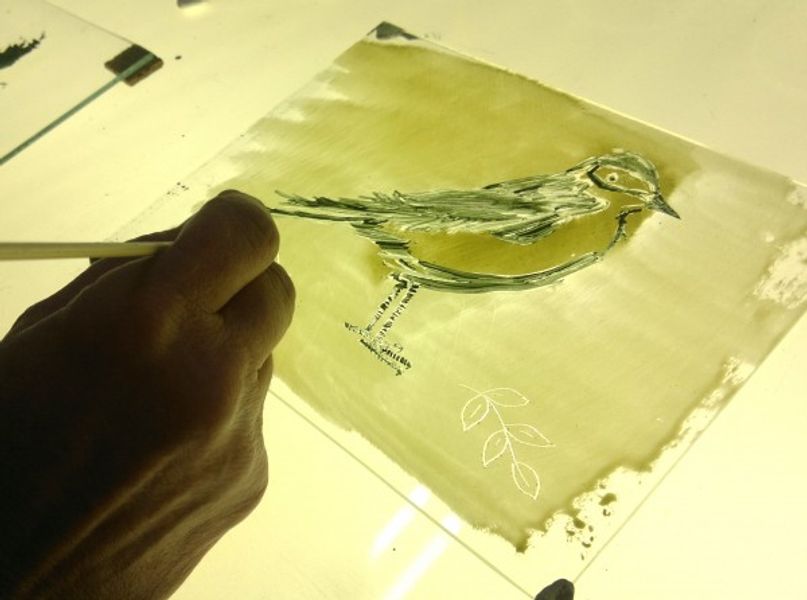 Painting a bird on glass in Nathalie's studio
