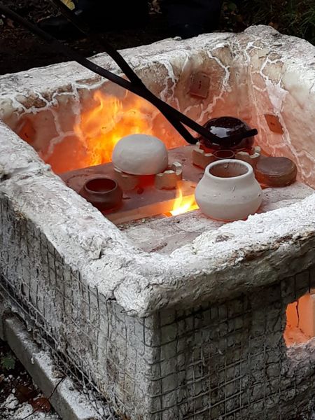 Using tongs to remove the pots