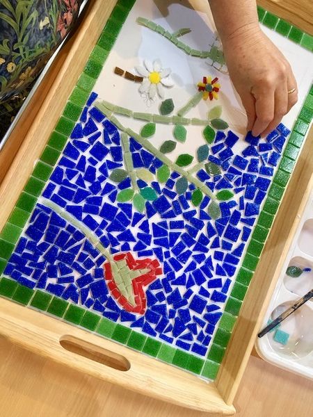 Student mosaic decorating a wooden tray