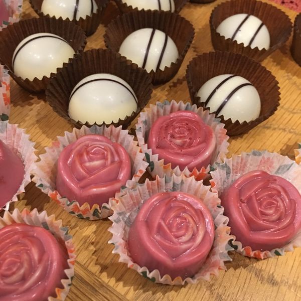 Rose chocolate moulded roses and white chocolate discs in the background.