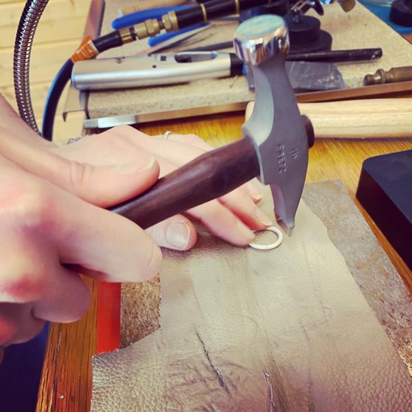 Texturing a ring with a hammer at the metal forming bench