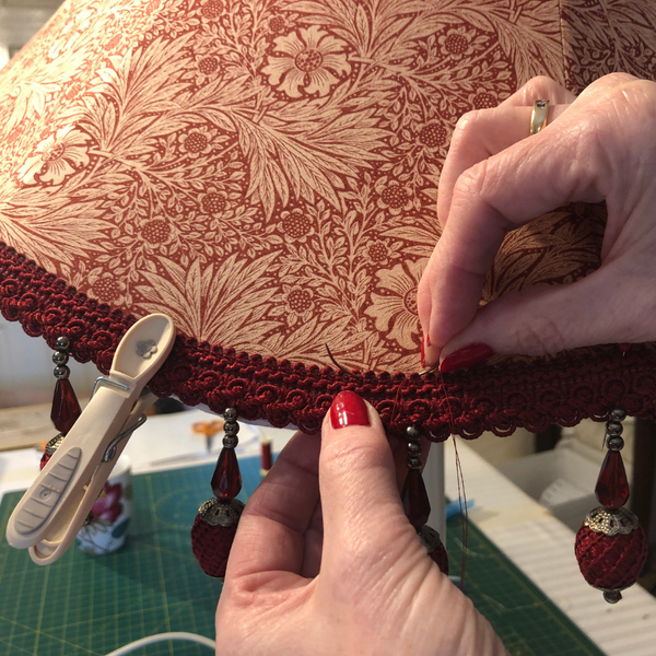 Tailor stitching trimming onto an handmade tailored lampshade in Morris