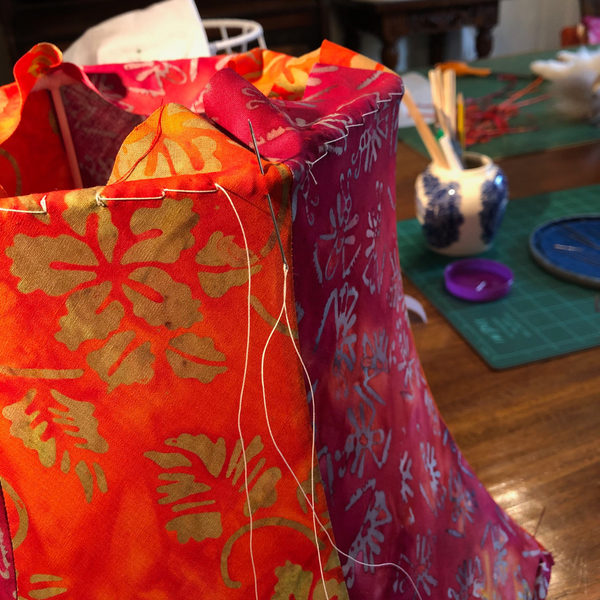 Lampshade stitching a tailored lampshade in red/orange batik & velvet trimming