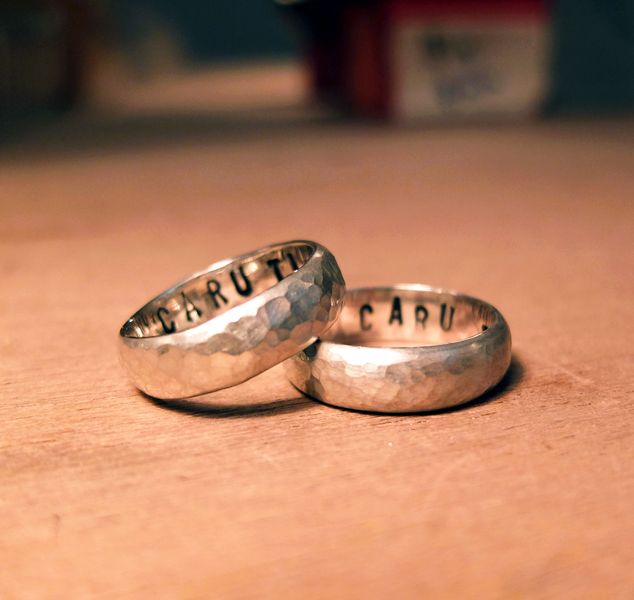 silver wedding rings with personalised stamping on the inside made by students