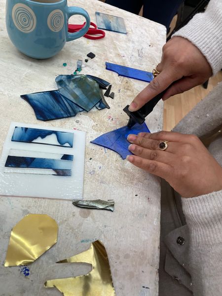 Participant cutting glass at fused glass workshop 