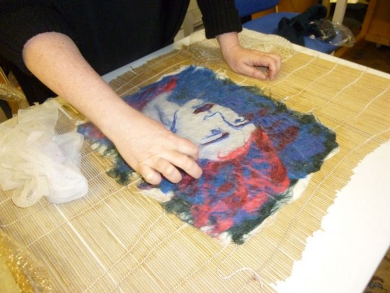 Student adding details to her felt portrait in a beginners feltmaking course in the Forest of Dean.