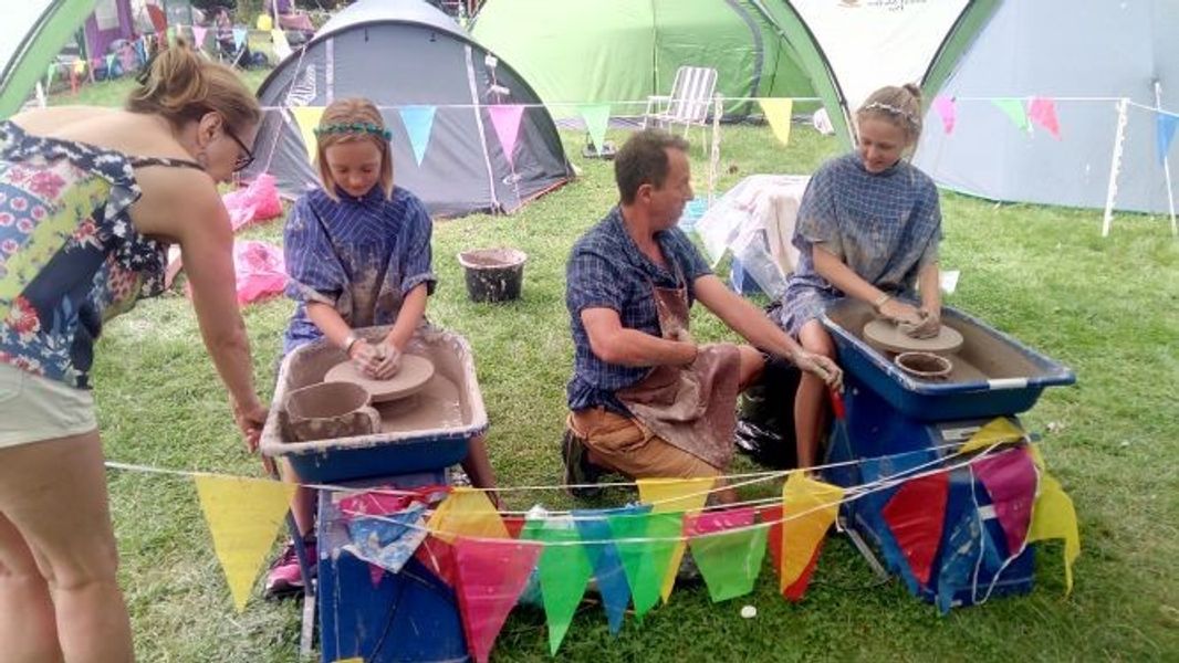 Girls try their hand throwing at Cambridge Folk festival with Potterydayz this year