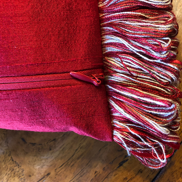 Bespoke scatter cushion in red and cream with ribbon trim and feature zip