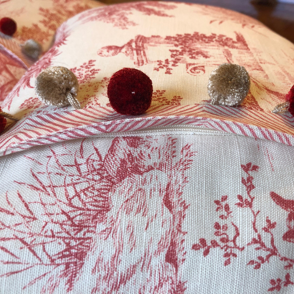 Bespoke scatter cushions in red and cream with pom pom trim and hodden zip