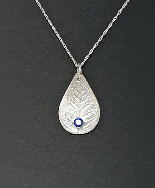 A fern leaf from the student's garden was used to texture her pendant.