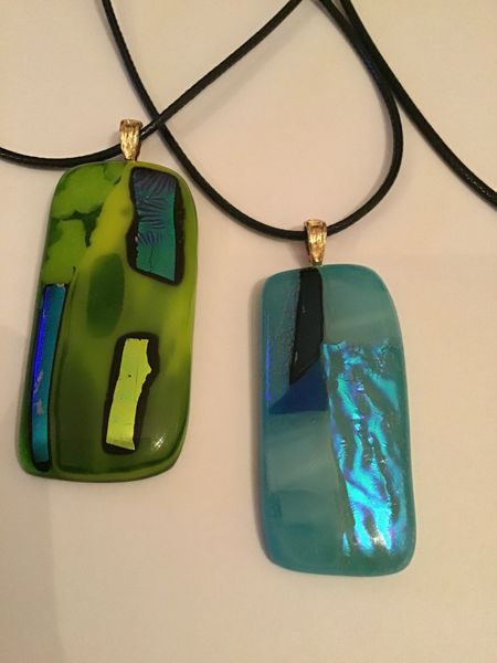 Beautiful slithers of dichroic glass catch the light beautifully on these stunning pendants. 