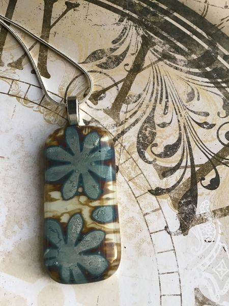 A beautiful fused glass pendant with silver foil encased within the layers.