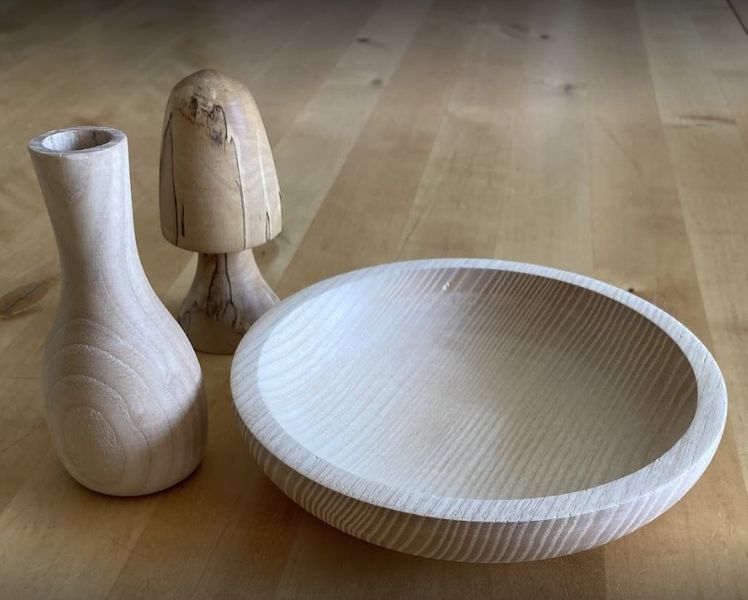 Turned wooden items including a toadstool, bud vase and bowl.