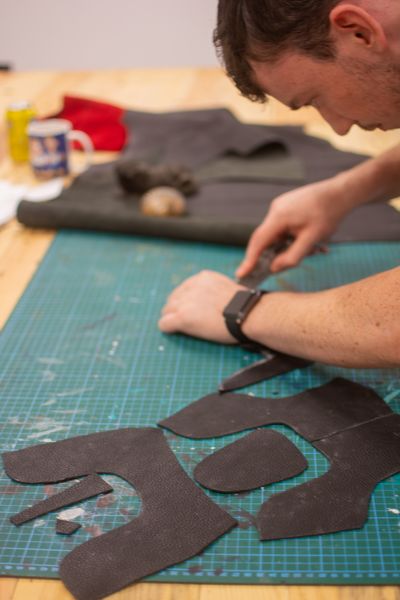 A student cutting a shoe pattern