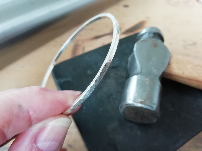 A hammered silver bangle nearly finished.