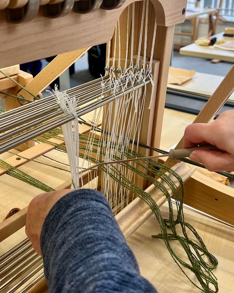 Threading the loom as a beginner.