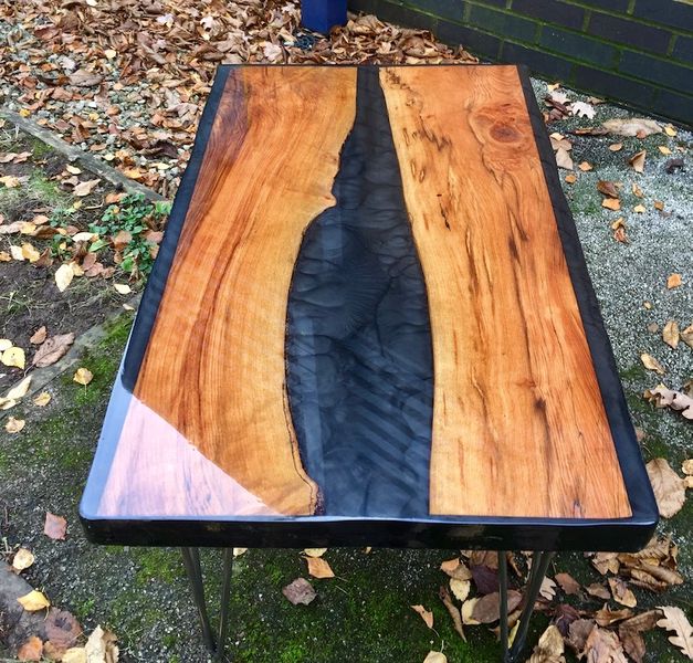 Beech river coffee table finished with matt metallic black resin through the centre and either side.