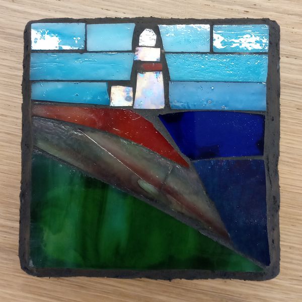 Stained glass lighthouse on slate.