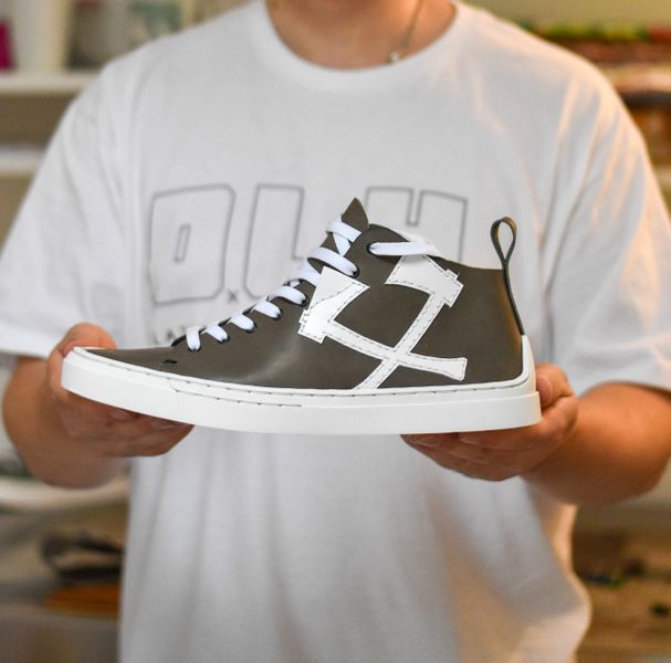 Holding a finished handmade sneaker
