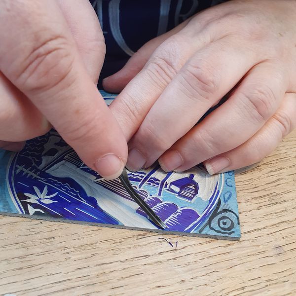 A student mastering detail on a willow pattern inspired carve
