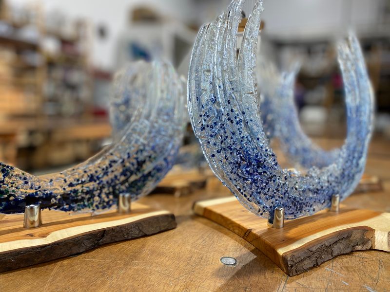 Fused Glass waves on their finished wooden bases made by students on the Vitreus Art Ocen Wave Glass Fusing course