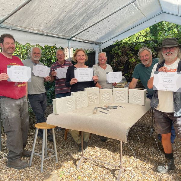 Happy students with certificates and finished pieces.