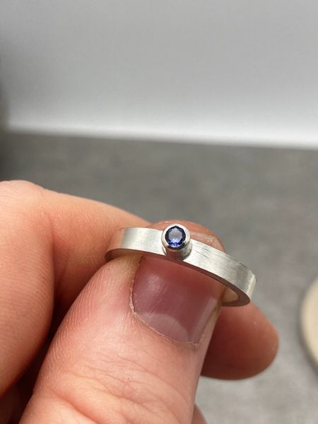 A silver ring with a tube set gemstone