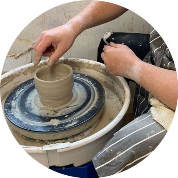 Learning to throw on the potters wheel.