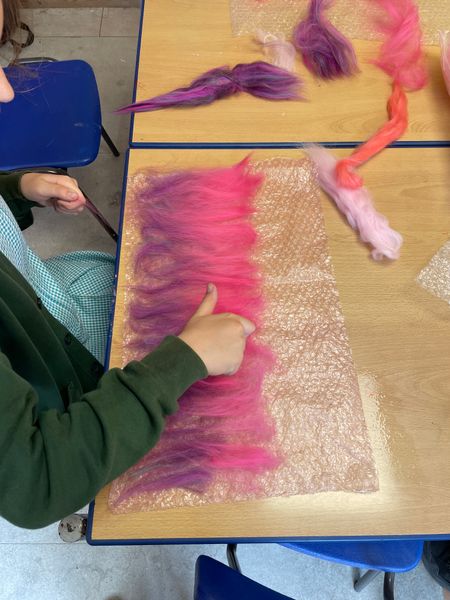 Olivia,  11 yrs old,  laying out fine wool tops for a wet felted rose made by