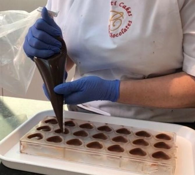 Tutor filling chocolate moulds